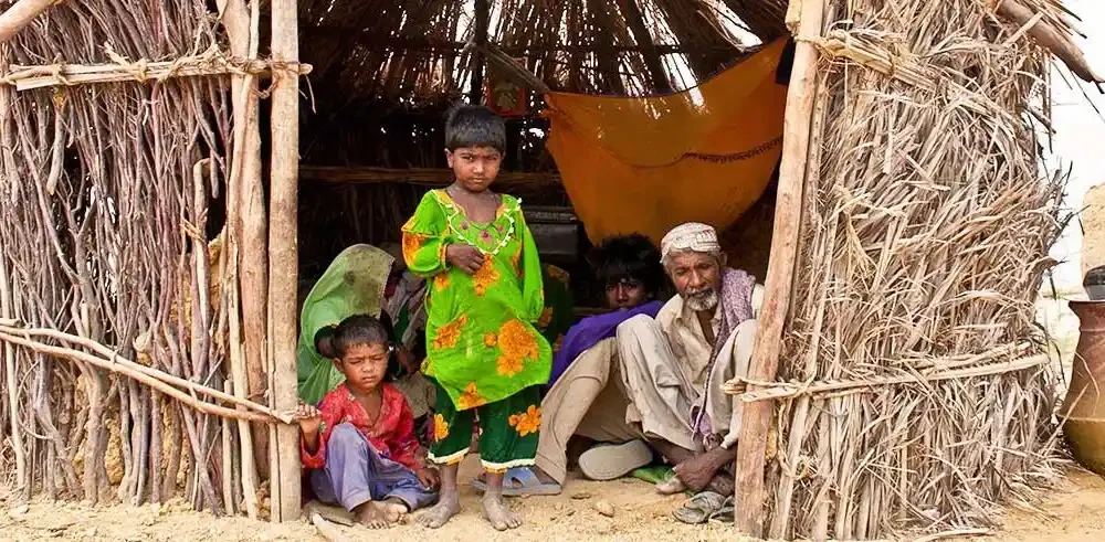 Family living in a small hut highlighting rural Pakistan healthcare needs