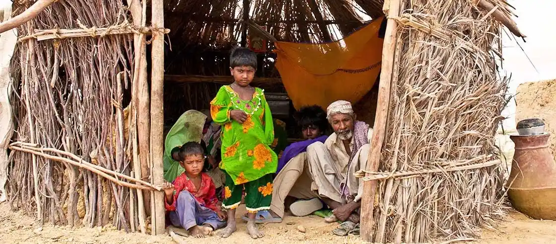 Family living in a small hut highlighting rural Pakistan healthcare needs